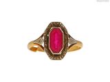 gros plan d'une bague en or avec une pierre rose