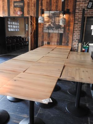 des tables et des tabourets dans une pièce avec un mur en briques