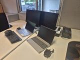 trois ordinateurs portables posés sur un bureau blanc dans un bureau