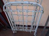 a white iron bed frame that has been placed on the floor