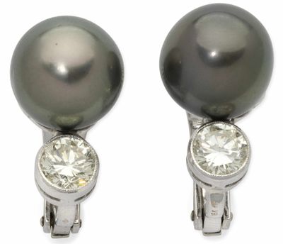 une paire de boucles d'oreilles en perles noires et diamants sur fond blanc