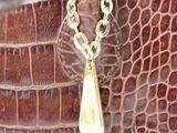 crocodile skin handbag with a gold chain and a tear charm