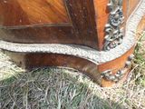 un gros plan sur une commode en bois posée dans l'herbe