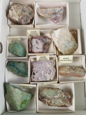 plusieurs boîtes contenant des cailloux de différentes couleurs, rangées dans une boîte munie d'étiquettes