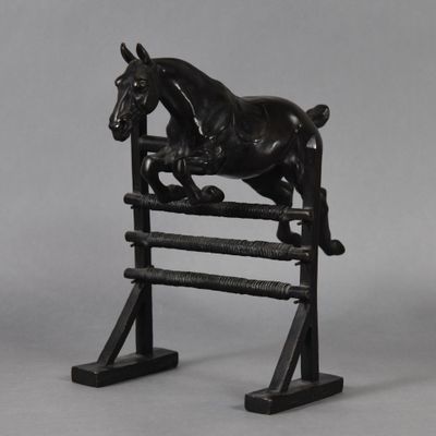 black horse jumping over a wooden fence on a gray background