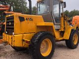 an image of a yellow tractor parked in a lot