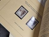 un livre ouvert avec des timbres, posé sur une table