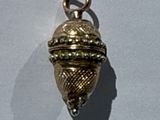 an image of a gold charm on a white surface