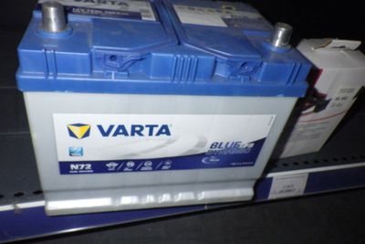 une batterie de voiture bleue et blanche posée sur une étagère