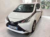 une Toyota AY blanche garée dans un garage