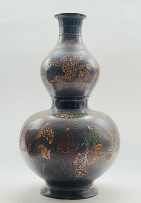 un vase noir orné d'un motif sur fond blanc