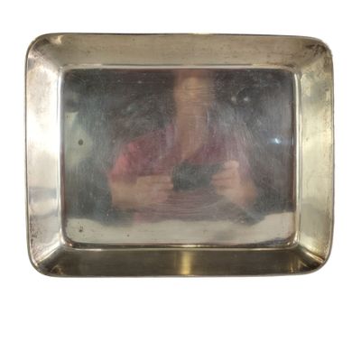 le reflet d'une femme dans un miroir posé sur une assiette en argent