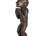 an image of a wooden statue of a man with a fish on his head
