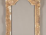 an ornate gold framed mirror on a wall with a white background
