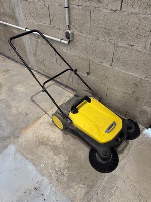 a yellow and black lawn mower sitting on the sidewalk