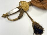 un pompon doré et bleu orné d'un médaillon doré
