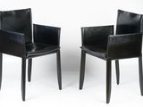 pair of black leather dining chairs with armrests against a white background