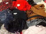 a pile of clothes that is on a bed