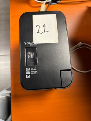 une boîte noire sur laquelle est collé un autocollant, posée sur un bureau