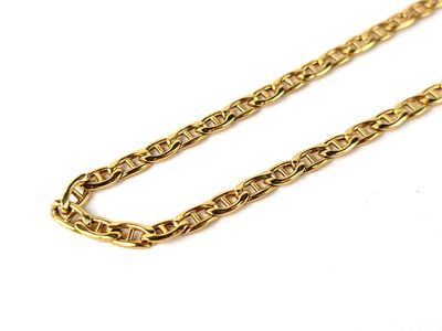 a close up of a gold chain on a white surface
