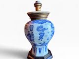 un vase bleu et blanc muni d'un couvercle, posé sur un socle