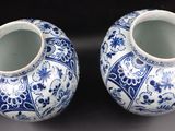 pair of blue and white vases sitting on top of a table