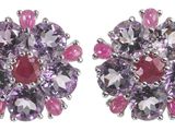 une paire de boucles d'oreilles en cristal rose et violet sur fond blanc