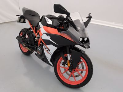 une moto noire et orange garée dans une pièce blanche