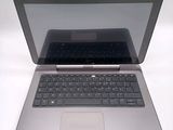 a silver laptop with a black keyboard on a white surface