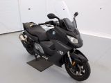 une moto noire garée dans une pièce aux murs blancs