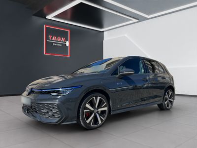 a grey volkswagen golf gt - line in a showroom