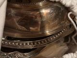 a silver plate with a spoon and spoon rest inside of it