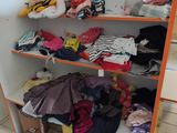 a shelf full of clothes and other items in a room