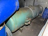 a large blue tank sitting next to a couple of blue barrels