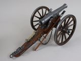 a toy cannon sitting on top of a wooden wheel