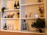 a shelf that has some bottles of wine and plants on it