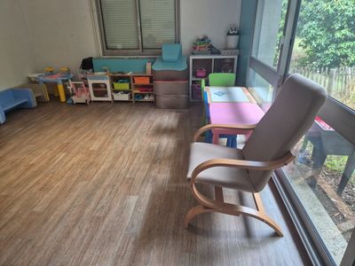 un parquet en bois massif dans une salle de jeux pour enfants, avec des chaises et des tables