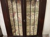 a cabinet that has a glass door on top of it