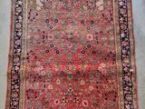 un tapis persan ancien à fond rouge et bordure bleue