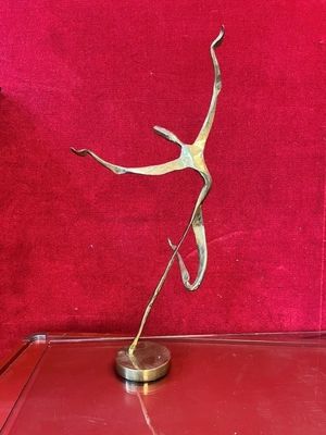 bronze sculpture of a dancing woman on a red background
