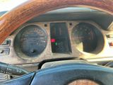 tableau de bord d'une voiture avec un volant en bois et des compteurs