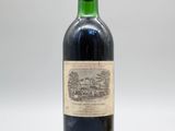 une vieille bouteille de vin posée sur une table blanche