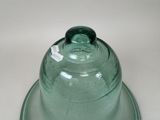 a green glass bowl with a lid on a white table