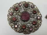 an image of a brooch and a pair of earrings on a table