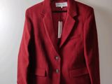 a red jacket hanging on a hanger on a wall