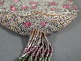 a close up of a beaded purse with a tassel hanging from it