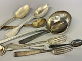 a lot of silver spoons and forks on the table