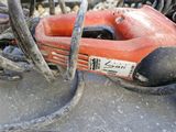 a red corded drill sitting on top of a pile of wires