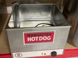 un hot-dog posé dans un récipient en métal sur le comptoir