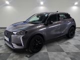 un 4x4 gris garé dans une pièce au sol en damier